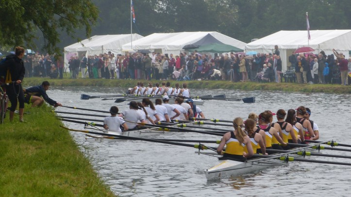 Pic 12. Women’s Division I. First & Third (Trinity College Boat Club, in white) have just bumped Clare (in yellow). They must now both stop racing and pull into the bank out of the way of the following crews. Even with the help of their bank party, this is not easy and mayhem can occur. In theory, the boat following these two (Christ’s) can try and catch the boat originally three ahead of them for a rare ‘over bump’ and go up three places.
