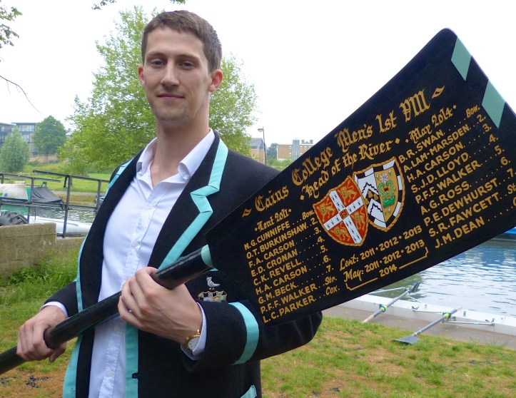Pic 24. Hugh Carson of Caius with a possibly atypical blade, one which records his several achievements in bump racing. He is wearing a Caius Boat Club blazer, usually described as ‘black with a Cambridge Blue stripe’. Legend says that the Blue stripe was added after a Caius crew beat the University crew but The Bumps says that ‘the shade of blue used by Caius has….. almost certainly changed over the years to mirror the colour used by the University’. 