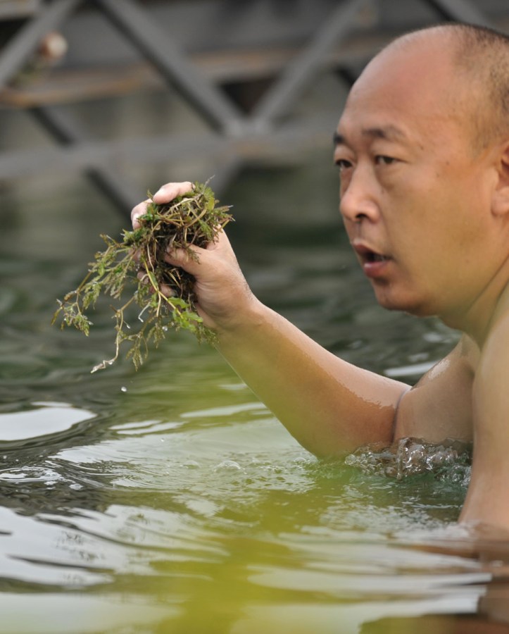 Shunyi, CHINA. Swimmer with the weed removes from the fin of GBR W2X, before the start of the women's double heat at the 2008 Olympic Regatta, Saturday, 09.08.2008 [Mandatory Credit: Peter SPURRIER, Intersport Images] 2008,Beijing,Olympic,Regatta, Games, , Rowing Course, Shun Yi Water Complex, Beijing, CHINA,