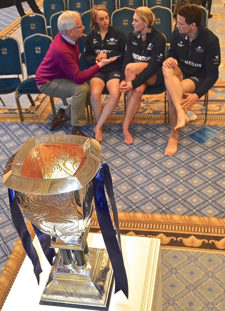 Pic 6. The ‘Voice of Rowing’, Robert Treharne-Jones, interviews three from the Oxford camp: women’s cox, Morgan Baynham-Williams, women’s number two, Emma Spruce and men’s number four, Josh Bugajski. In the foreground is the women’s race trophy.
