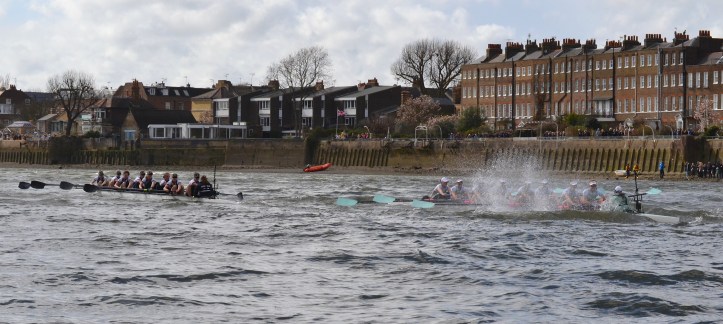 Pic 8. + 9 min 49 sec: The blue window above the head of Oxford’s ‘3’ marks the mid-way point. At the top of the Hammersmith bend, Cambridge, on the worst station and rowing in Oxford’s puddles, began to fall back as the conditions ‘got Biblical’. Matthew 8:24. And behold, there arose a great storm on the sea, so that the boat was being covered with the waves……