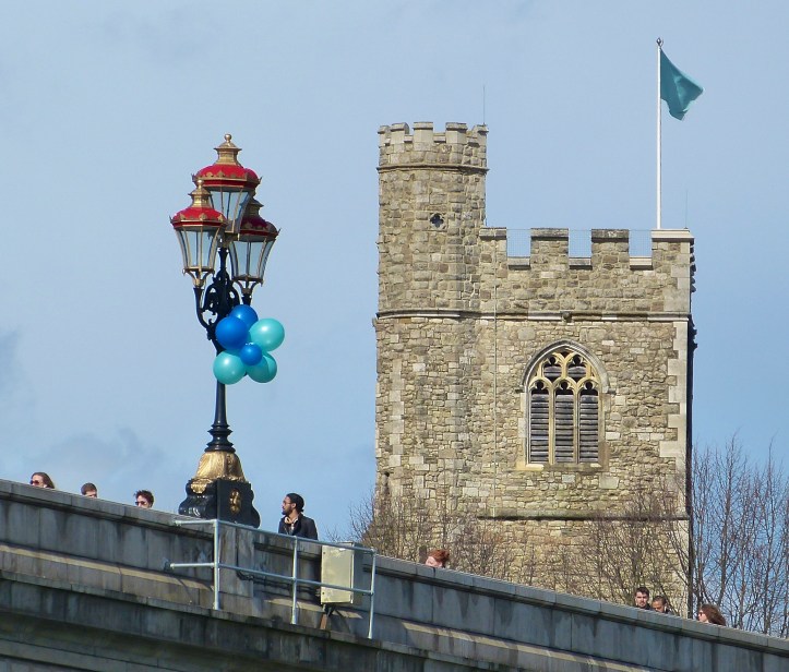 Pic 9a and 9b. For the Women’s Race, a dark blue flag flew at St Mary’s, Putney, and a light blue one at All Saints, Fulham, the churches at opposite ends of Putney Bridge. As Chris Dodd explained, ‘they signified the stations of crews, not the Cross’.
