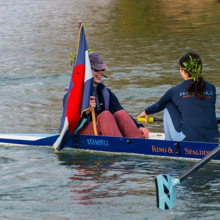 Picture 6: Women’s side Captain and W1 cox James Roberts after we achieved Blades in Lent Bumps. It’s traditional that crews achieving a bump place foliage – collected from the side of the river – in their hair for the row home. Pembroke also allows crews achieving Blades to carry the club flag home from the final bump. Photo: Giorgio Divitini, a regular photographer of Bumps and other races on the Cam.