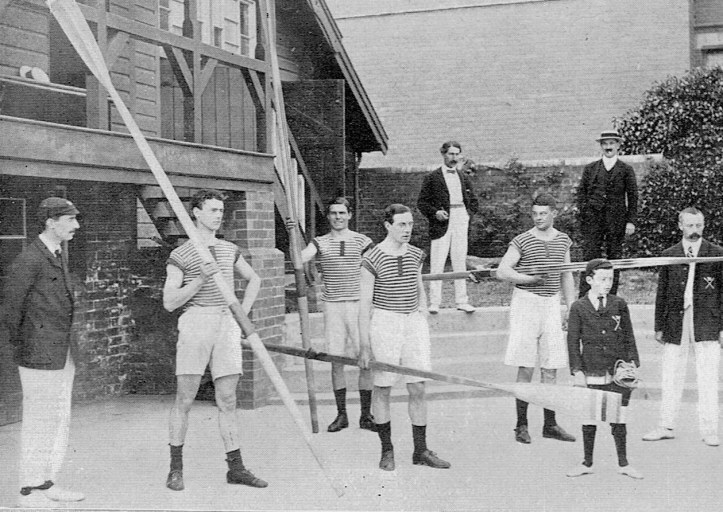 Pic 9. The Hereford Junior Four brings out the oars. On the left is the Hon. Sec, Mr. Phillips, and on the extreme right, Mr. Hammond, the Captain and Coach.