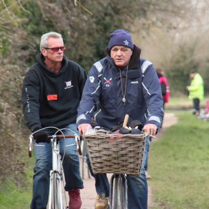 Picture 10: Kev cycling along the towpath during Lents, the handle of the ‘overlap’ bell just visible poking out of the basket. The serious-looking gentleman behind is Paul Meadows, the friendly and dedicated coach of our second women’s boat. Photo: Bjoern A. Zeeb, another regular bumps photographer.