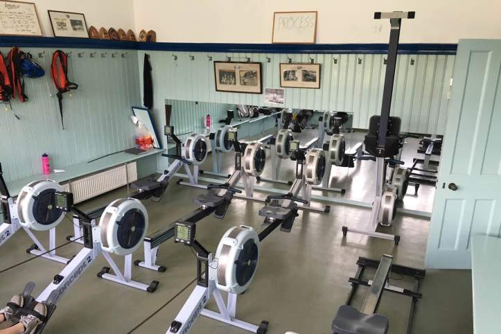 Picture 2: Our erg room, complete with photos of old Henley crews. The hooks on the wall suggest that this was once a changing room; I believe it used to be for the lower men’s boats. Photo: CL, with an iPhone 6 and VSCO.