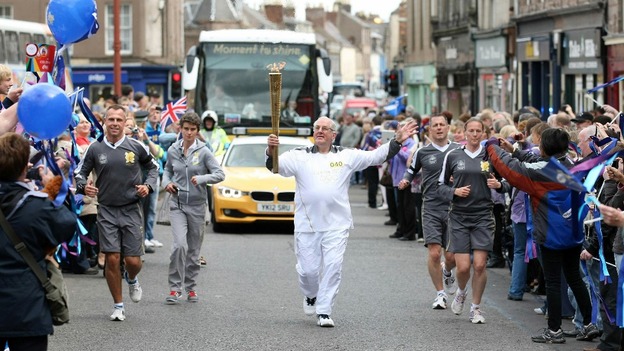 Jim Brown carries the Olympic flame on 12 June 2012. Picture: itv.com