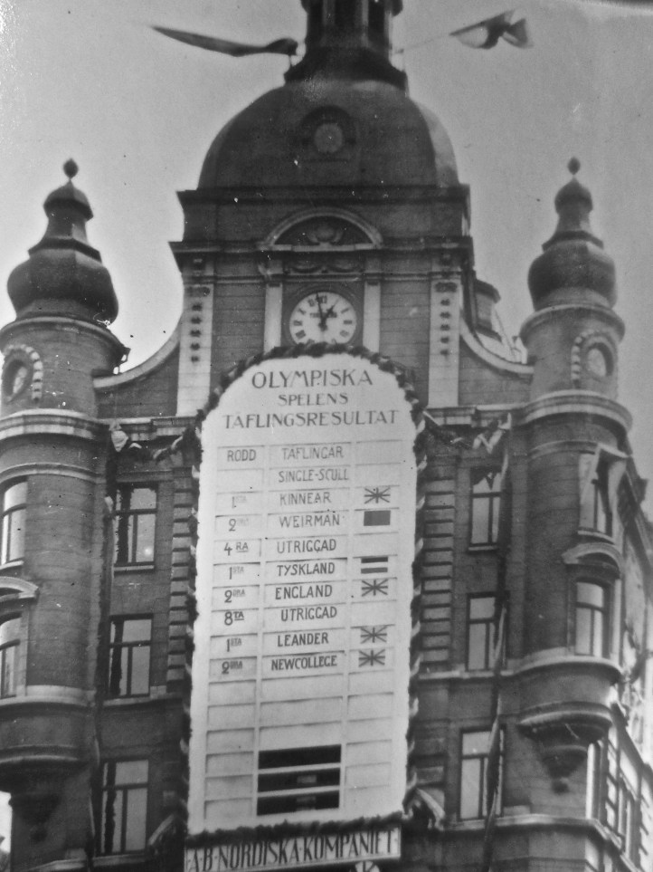 The results board in close up. Missing the inrigged fours results for some reason, it reads: The Olympic Games. Rowing events. Single scull 1st Kinnear 2nd Weirman [sic] Fours outrigged 1 Germany 2 England Eights outrigged 1 Leander 2 New College