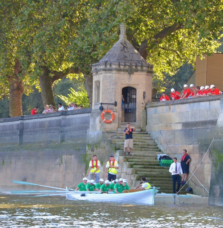 Watched by the Lord’s crew (in red), the Commons crew (in green) goes afloat from Black Rod’s Steps. ‘Black Rod’ is, in theory, responsible for maintaining the buildings, services, and security of Parliament. His steps are a reminder of the time when travelling by river was faster, safer and more comfortable than attempting to use the unsatisfactory roads.