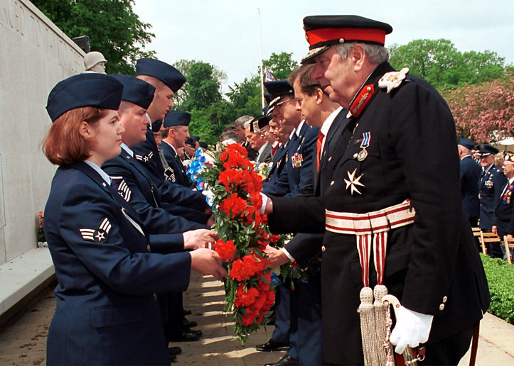 010528-F-2021R-017 Senior Airman Rebecca A. Baucum (left) passes a wreath to Her Majesty's Lord Lieutenant of Cambridgeshire James Crowden during the Madingley Memorial Day Commemorative Service on May 28, 2001, at the Cambridge American Military Cemetery, Coton, Cambridge, England. This year marks the 57th annual memorial service honoring the American servicemen and women who are buried here and those listed on the Wall of the Missing. The cemetery was dedicated on July 16, 1956, as the only permanent American World War II cemetery in the British Isles. Baucum is attached to the 48th Communication Squadron, 48th Fighter Wing, RAF Lakenheath. DoD photo by Airman 1st Class Joanna E. Reihle, U.S. Air Force. (Released)