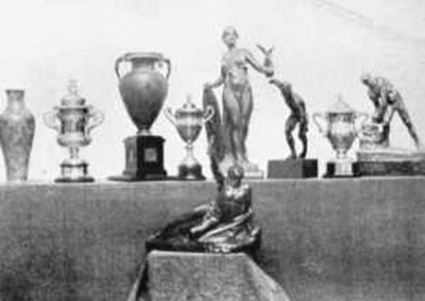 Some of the challenge cups and trophies presented at the 1908 Olympic Games. The cycling and rowing trophies in the centre and The Greek Trophy for the Marathon Race, presented to Johnny Hayes to the fore.