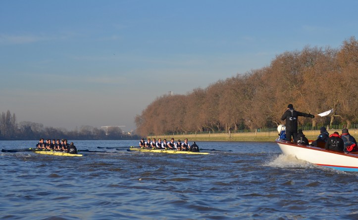 Just off the start and half-way along Putney Embankment, “Daniel” (left) on Surrey and “Acer” (right) on Middlesex. “Acer” had a two seat lead after the first 30 strokes. I must give my usual caution about the parallax error inherent in picturing a side-by-side race from behind and from an angle, whereby the boat nearest the camera appears to be more ‘up’ than was the actual case.